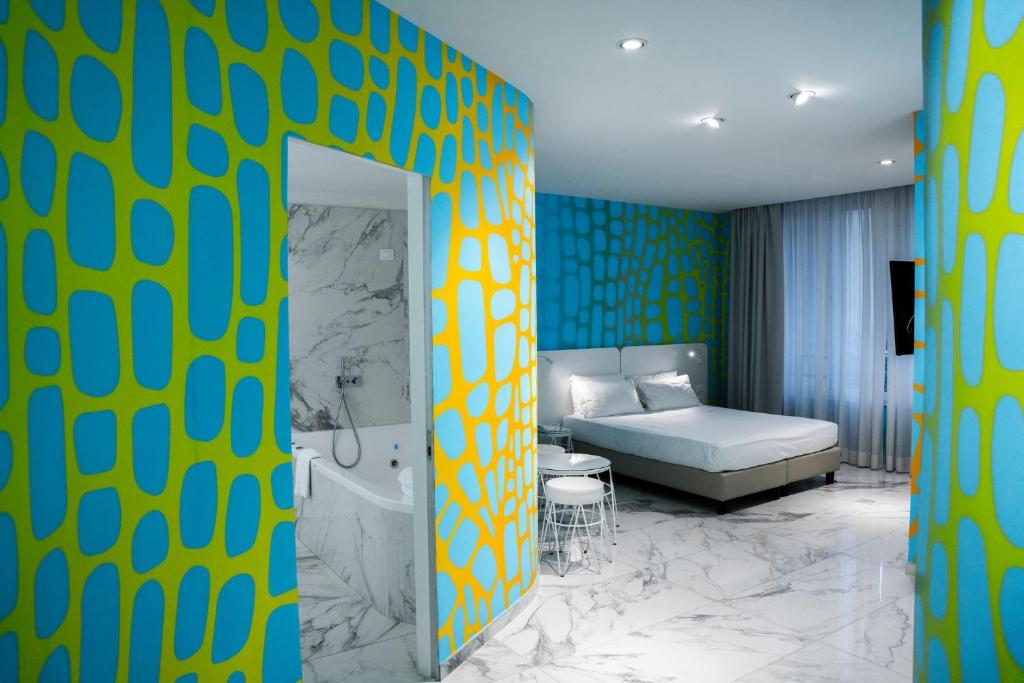 um quarto de hotel com uma cama e uma casa de banho em Soul Art Hotel em Nápoles