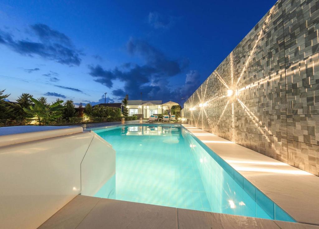 una piscina con luces en un edificio en Villa Dianna 3bd Private Swimming Pool, en Ambelókipoi
