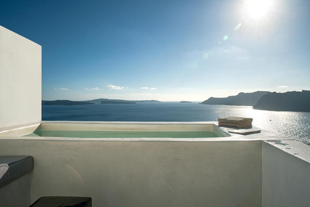 d'une baignoire au bord d'un bâtiment donnant sur l'océan. dans l'établissement Big Blue Villa by Caldera Houses, à Oia
