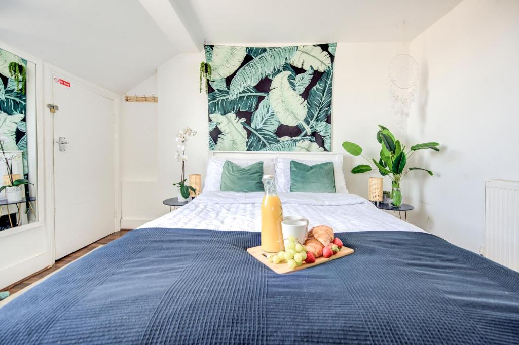 a tray of fruit on a bed in a bedroom at The London Perfect Attic - sleeps 8 in London