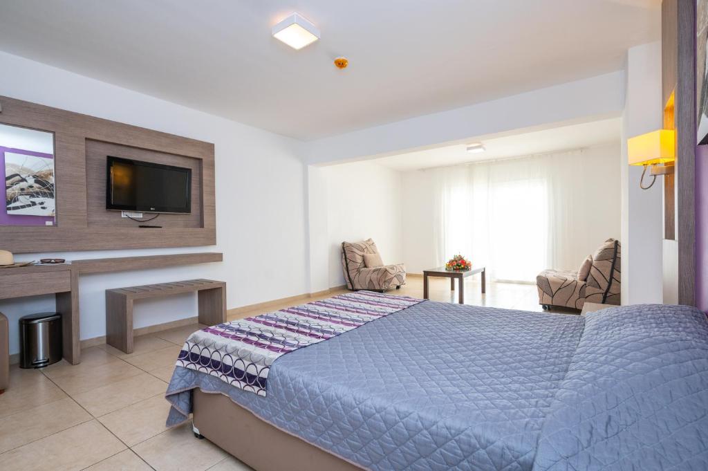 a hotel room with a bed and a tv at New Famagusta Hotel & Suites in Ayia Napa