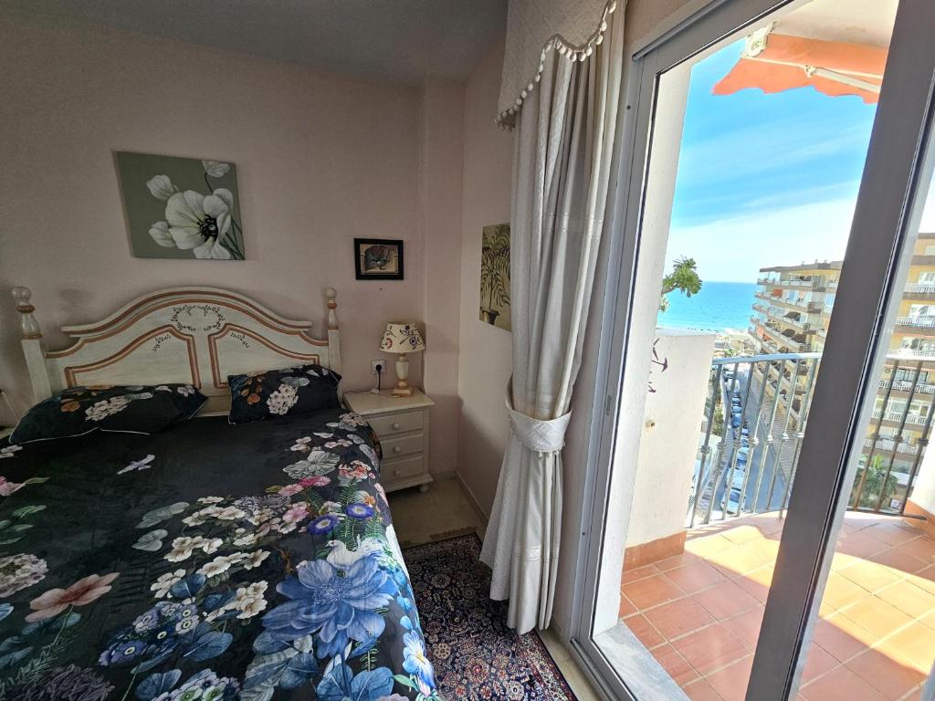 a bedroom with a bed and a sliding glass door at Rymlig lägenhet för 7,8 persons in Los Boliches, Fuegirola in Fuengirola