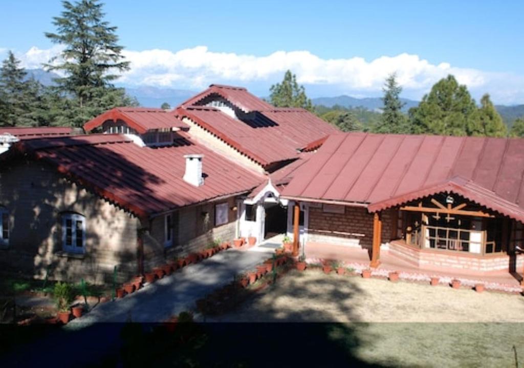 een afbeelding van een huis met een rood dak bij Ranikhet Club Uttarakhand in Rānīkhet