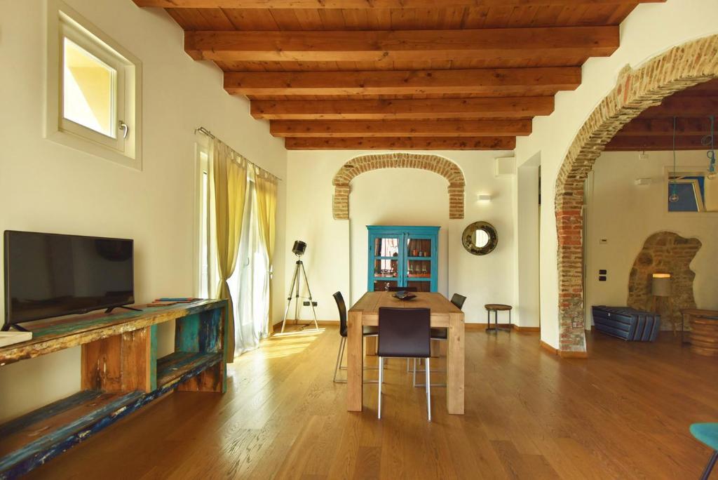 uma sala de estar com uma mesa e uma televisão em Welc-ōM Casa a colori nel borgo em Monselice