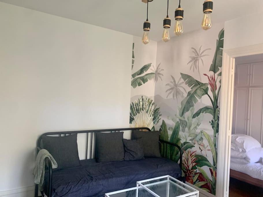 a living room with a blue couch and a bed at Pantin Paris in Pantin