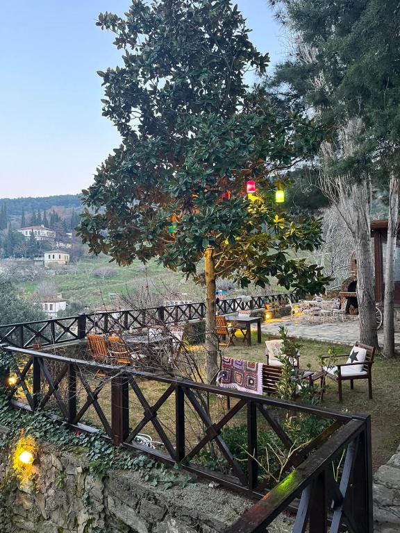 a wooden bridge with benches and a tree at ŞİRİNCE BAHÇE OTEL in Selcuk