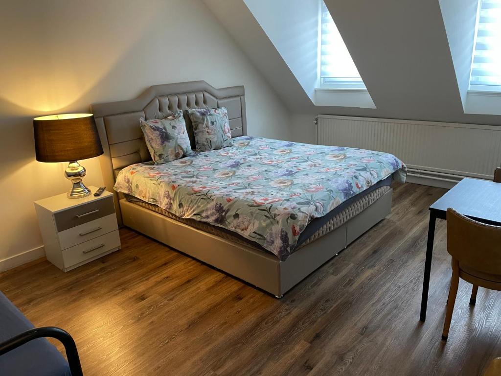 een slaapkamer met een bed en een tafel met een lamp bij MG BB in Venlo