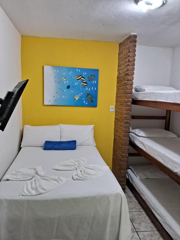 a room with a bed and bunk beds in it at Pousada Familia Viva Trindade in Trindade