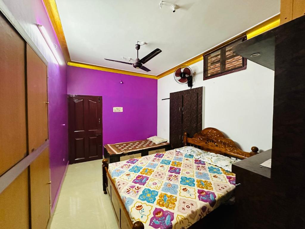 a bedroom with a bed with purple walls at Amaravathi Home Stay in Tiruvannāmalai