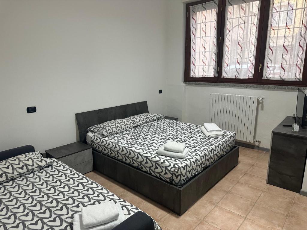 1 dormitorio con 2 camas, mesa y ventanas en Jessy house, en Cantù