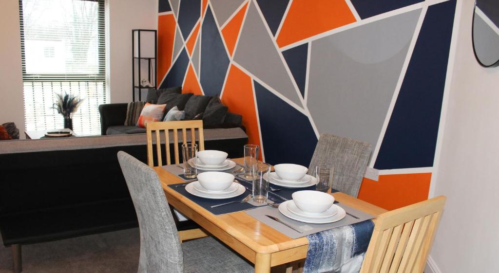 a dining room with a table with dishes on it at ChicCityApartment - Free parking - Perfect for contractors - Close to Molineux Stadium in Wolverhampton