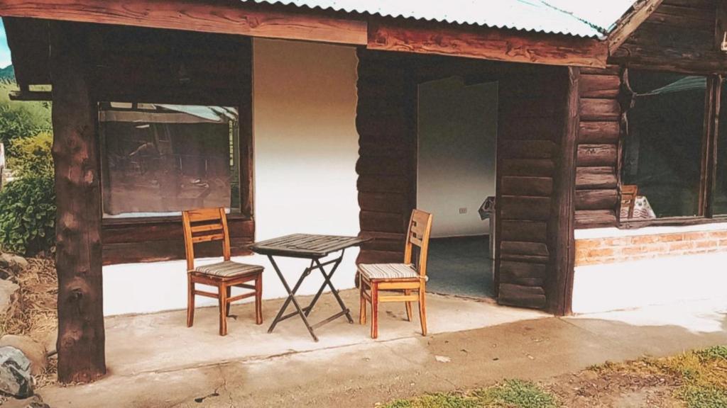 a table and two chairs on a porch of a cabin at Cabaña Emilio (El Hoyo) in El Hoyo