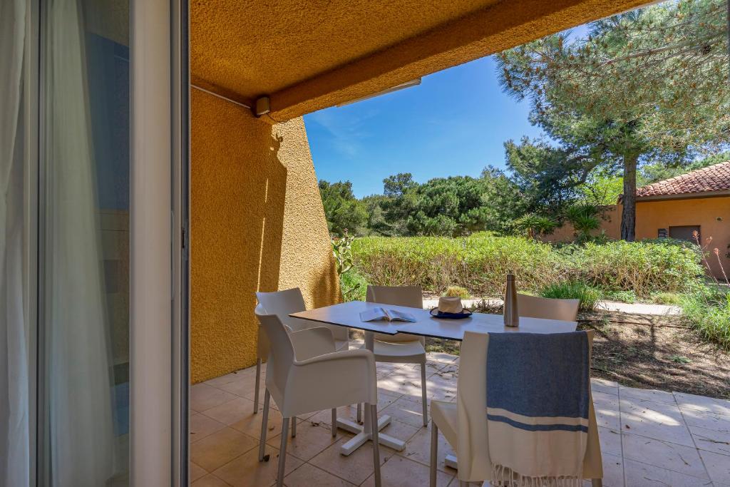 a patio with a table and chairs on a patio at Belambra Clubs Presqu&#39;île De Giens - Riviera Beach Club in Hyères