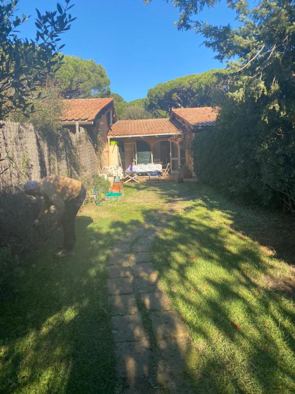 a person standing in a yard next to a house at LE DUNE SUL MARE in Castiglione della Pescaia