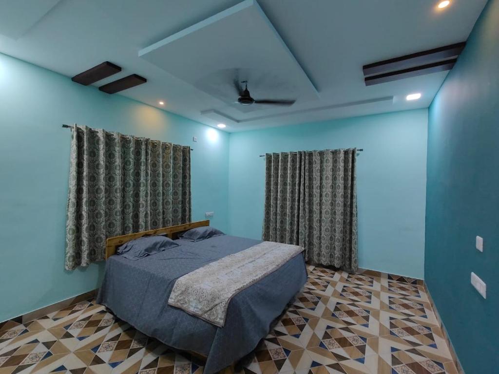 1 dormitorio con 1 cama con paredes y cortinas azules en R R Villa, en Alibaug