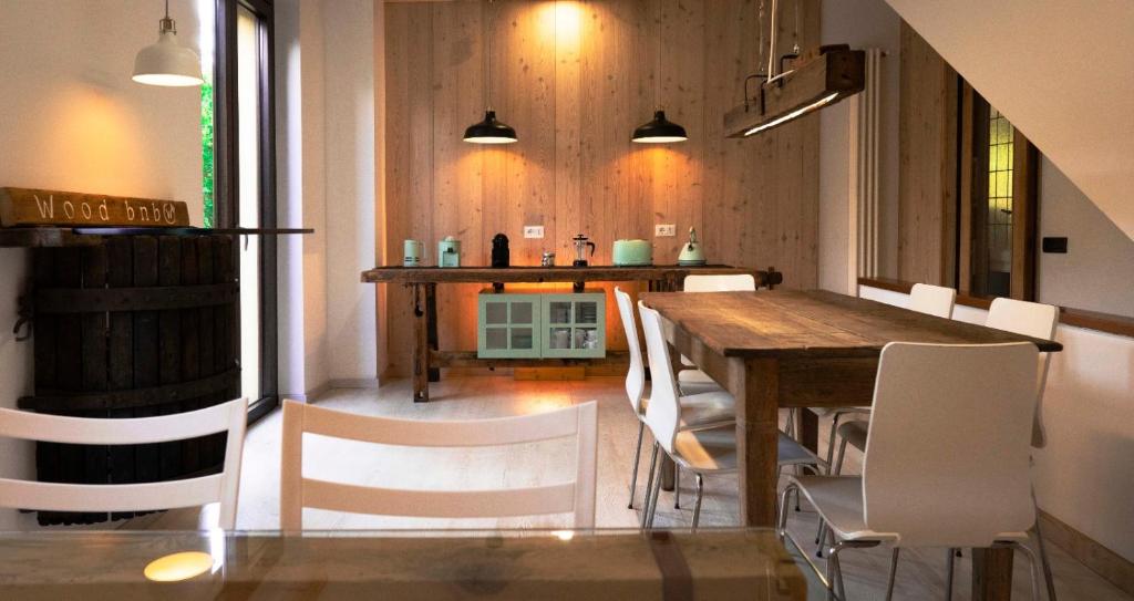 une salle à manger avec une table en bois et des chaises blanches dans l'établissement WoodBnb, à Cassina Rizzardi