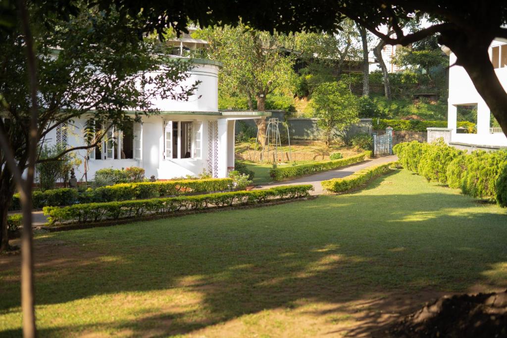 une maison blanche avec une pelouse devant elle dans l'établissement Fortuna Heritage Home, à Kandy