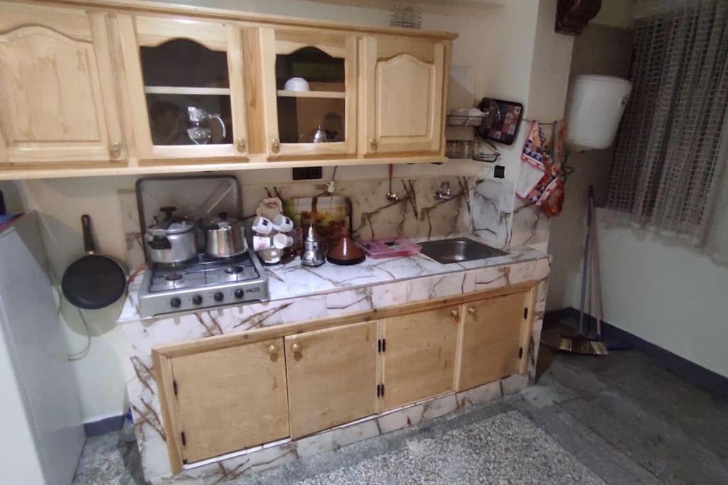 a kitchen with a sink and a stove and cabinets at Résidence Gharnata in Marrakech