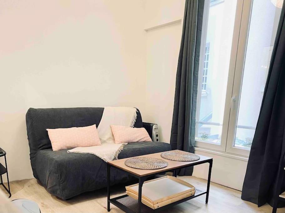 a living room with a couch and a table at EXIGEHOME-Versailles à 2 pas du château in Versailles