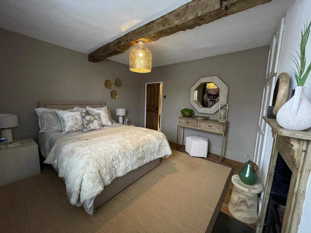 1 dormitorio con cama y espejo en 3-storey luxury Georgian house, High St, Henley-in-Arden, en Henley-in-Arden