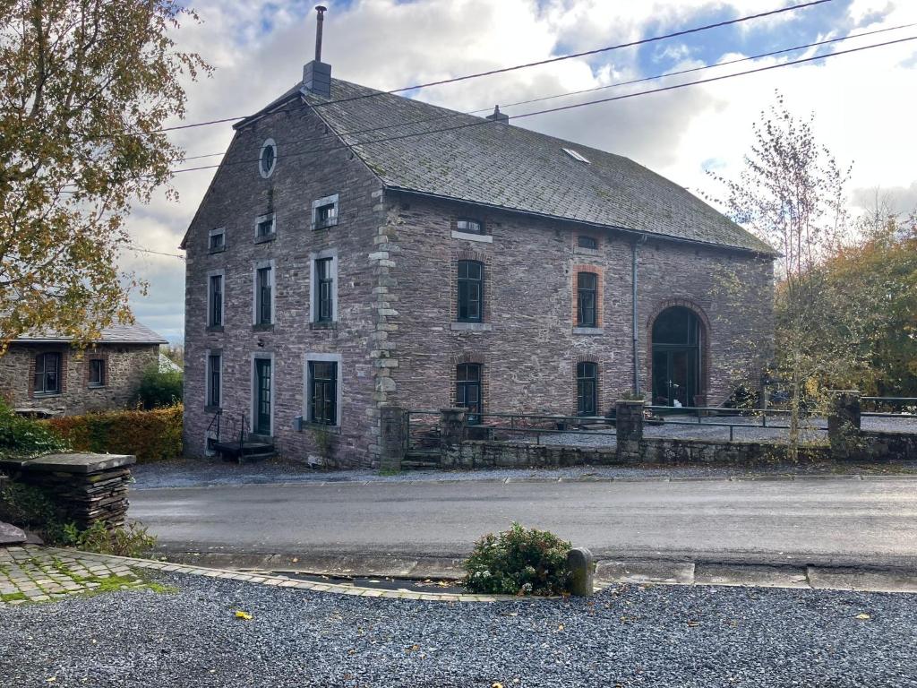 an old stone building with a roof on a street at B&B Ferme1883 in Lierneux