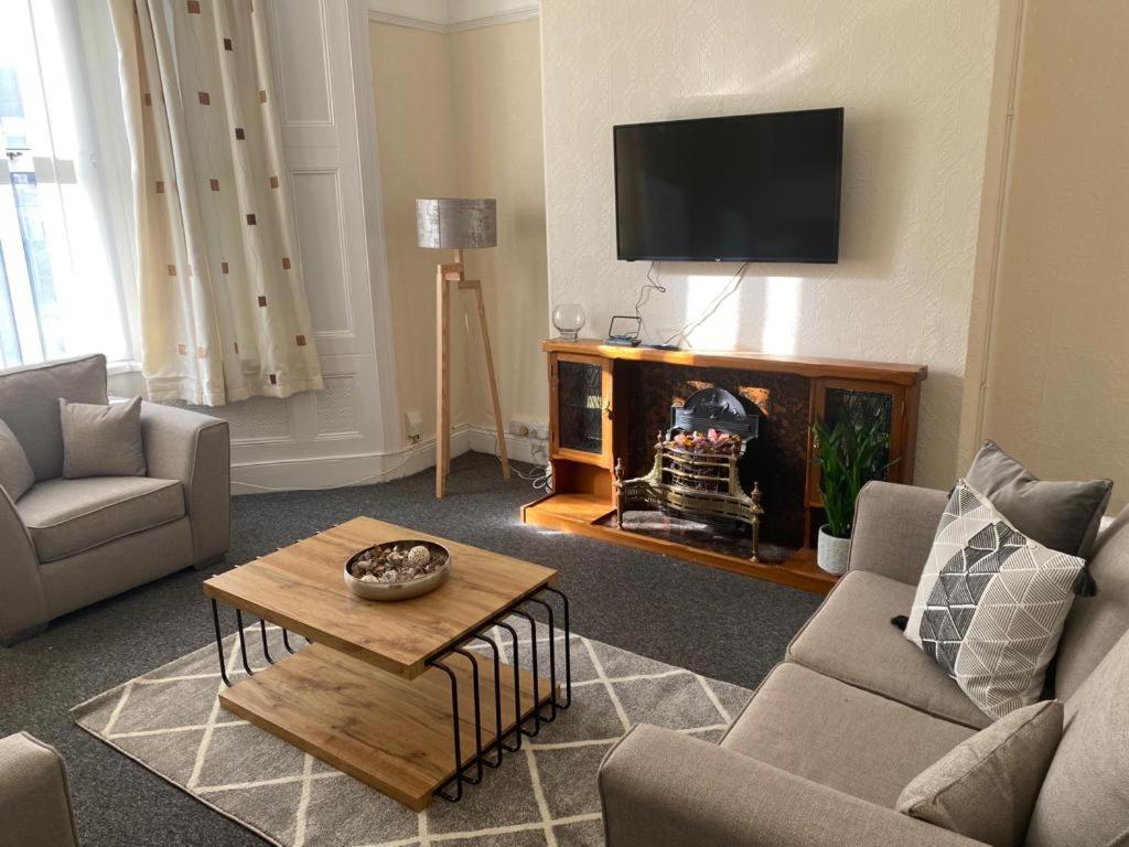 a living room with a fireplace and a tv at Chepstow House (5 BR with FREE on-steet parking) in Newport