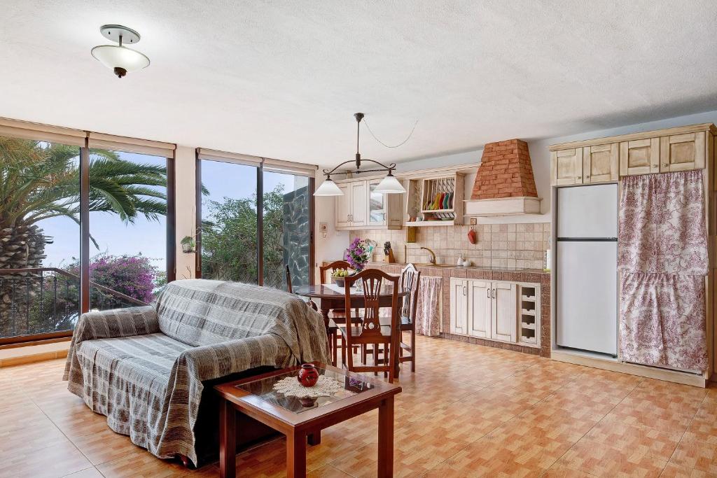 uma cozinha e sala de estar com um sofá e uma mesa em Casa Titi em Las Indias