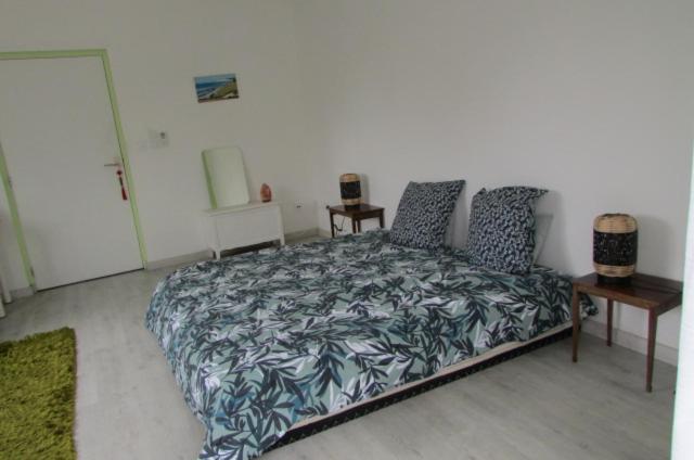 - une chambre avec un lit et 2 tables de chevet dans l'établissement Chambre 20m2 avec salle de bain privée dans maison en bois, à Lavaur