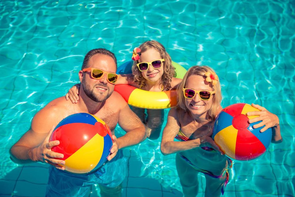 a group of people in a swimming pool holding beach balls at Beautiful Caravan With Decking At Hoburne Devon Bay, Ref 54058f in Paignton