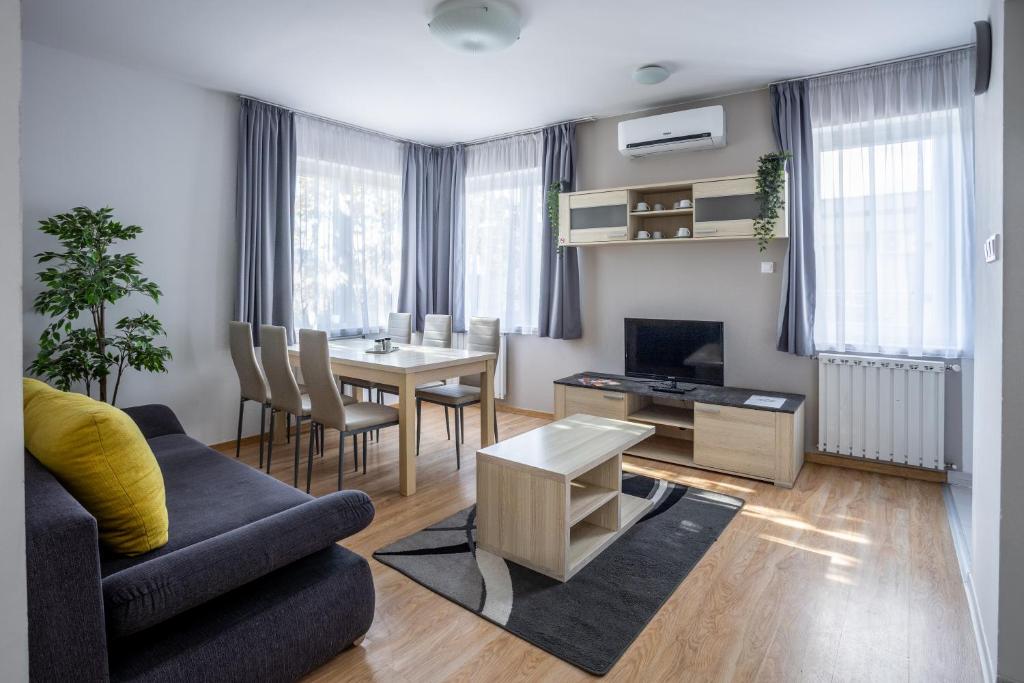 ein Wohnzimmer mit einem Tisch und einem Esszimmer in der Unterkunft Maple Tree Budget Apartments in Budapest