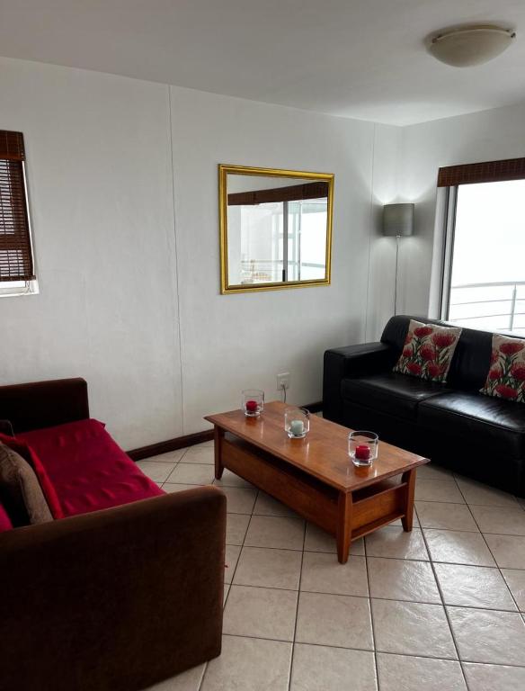 a living room with a couch and a coffee table at Ocean View B1001 in Bloubergstrand