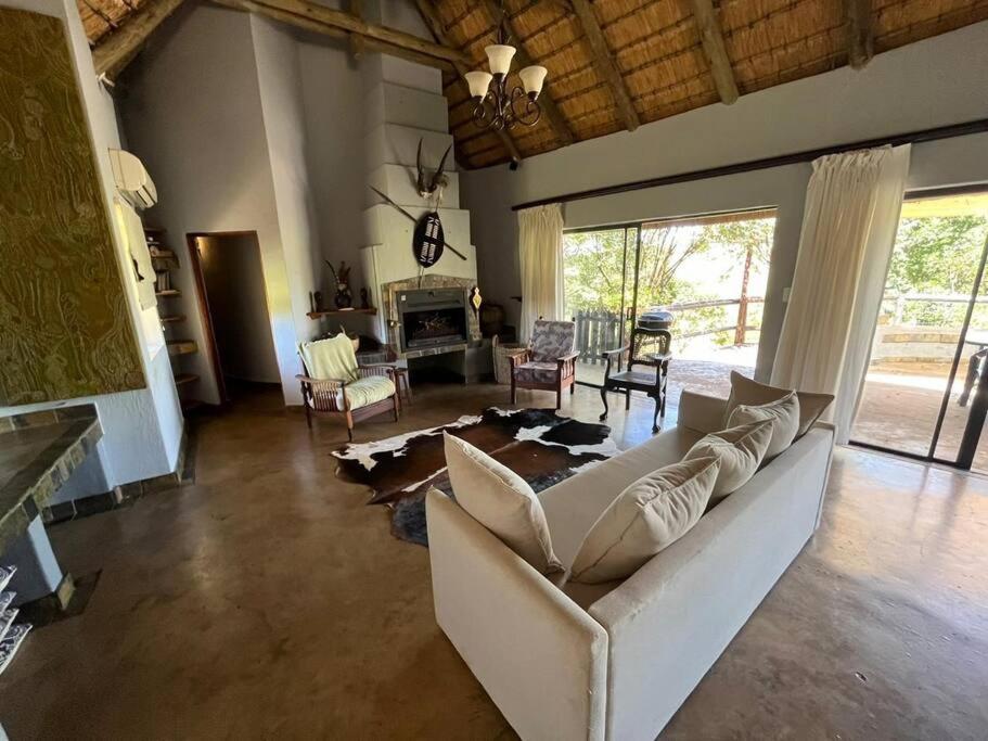 a living room with a white couch and a fireplace at Mpofu Lodge in Bergview