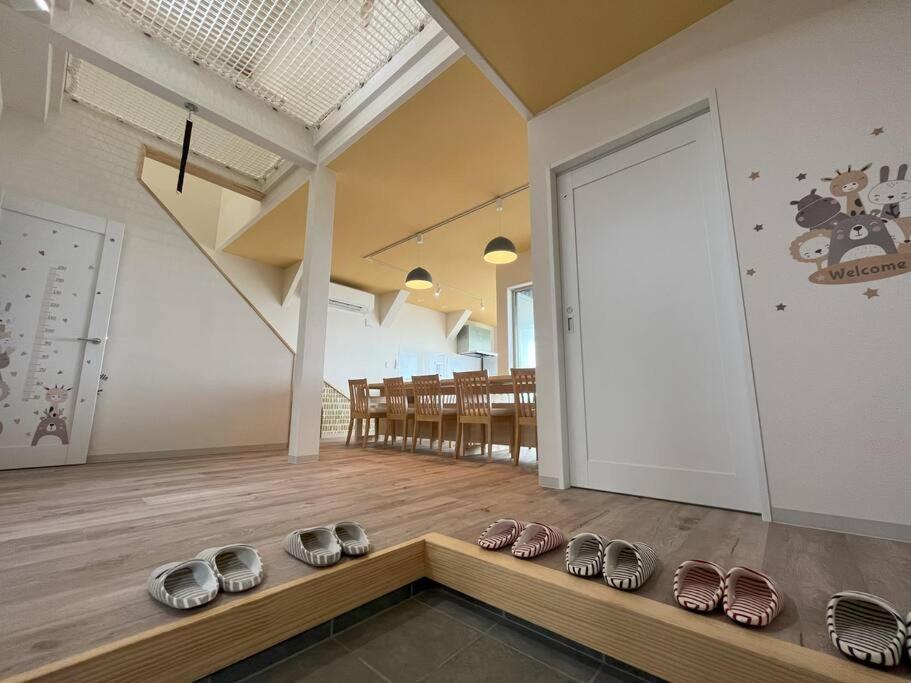 una habitación con una fila de zapatos en un suelo de madera en 子どもがおもいっきり楽しめる一軒家　taiza child, en Kyotango