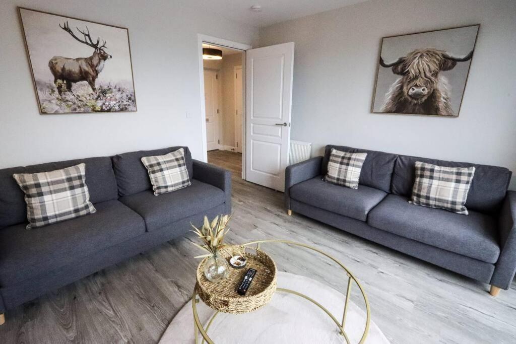 a living room with two couches and a deer on the wall at City Retreat by the Castle Free Designated Parking in Stirling