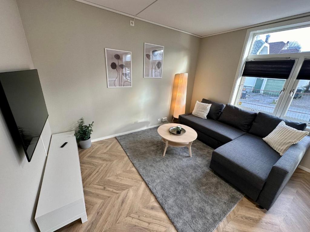 - un salon avec un canapé noir et une table dans l'établissement Modern Central Apartment Apt 105, à Stavanger