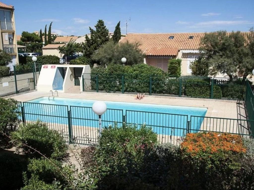 een zwembad met een hek eromheen bij Appartement Fleury-Saint-Pierre-la-Mer, 3 pièces, 5 personnes - FR-1-229D-268 in Fleury