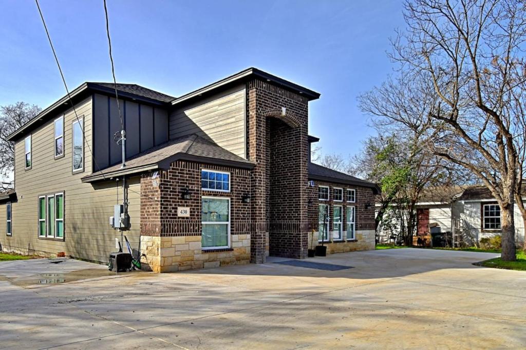 a house with a brick building with a parking lot at Stunning 6 Bedroom Near Downtown in San Antonio