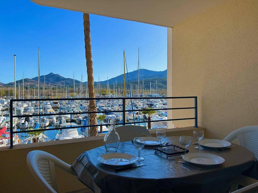 - une table avec des verres à vin et une vue sur le port dans l'établissement T2 cabine 4 pers. près plage, parking, vue port - Argelès - FR-1-388-90, à Argelès-sur-Mer