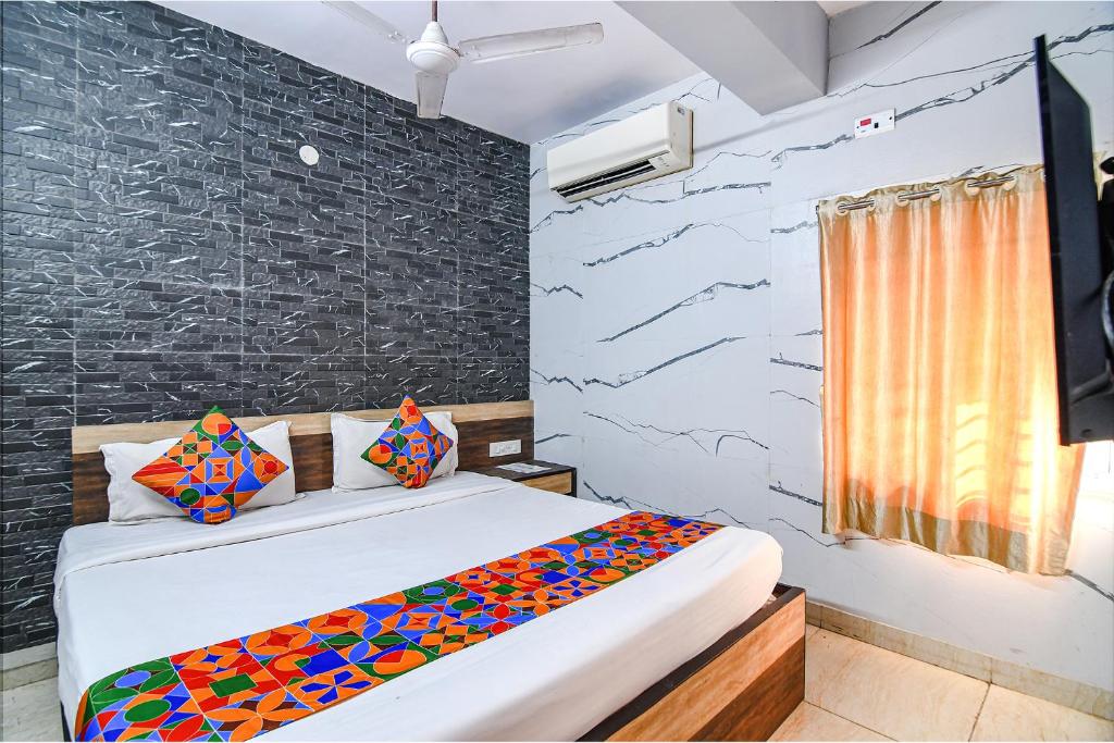um quarto com uma cama e uma parede em FabExpress Subh Residency em Sāntrāgāchi