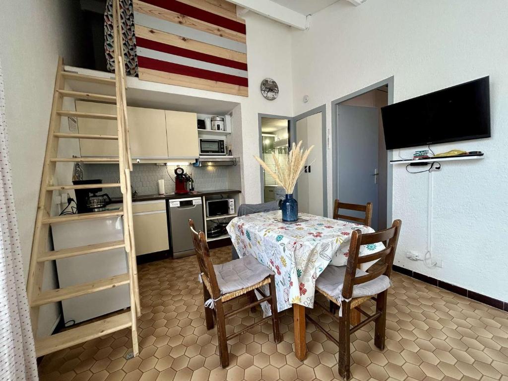 - une salle à manger avec une table, des chaises et des lits superposés dans l'établissement Appartement 2 pièces mezzanine climatisé avec terrasse - 450m de la plage, parking inclus, Saint Cyprien - FR-1-225D-149, à Saint-Cyprien