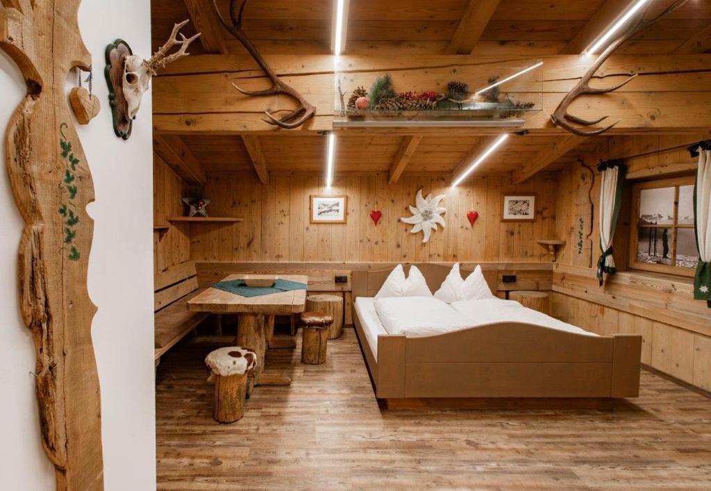 a room in a log cabin with a bed and a table at Chalet Edelweiß in Saalbach-Hinterglemm