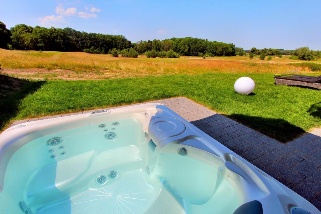 un jacuzzi con una pelota de golf en el césped en Luxus_EG_Fewo TEE ONE, en Göhren-Lebbin