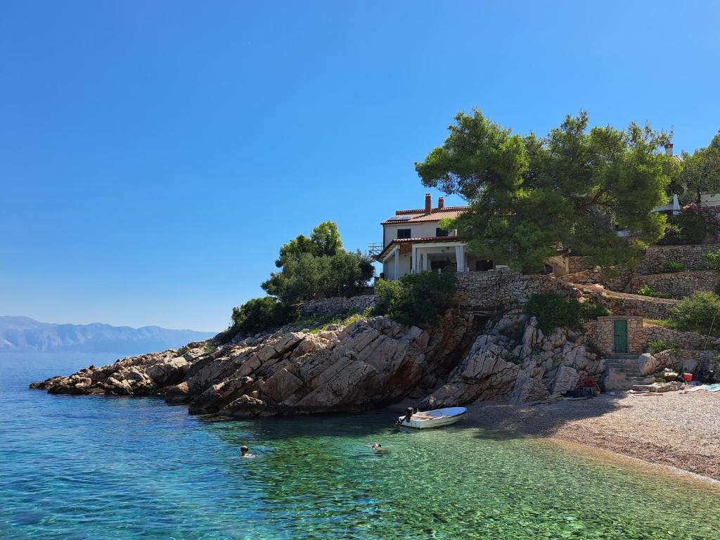 een huis op een rotseiland in het water bij Robinson Ane in Gdinj