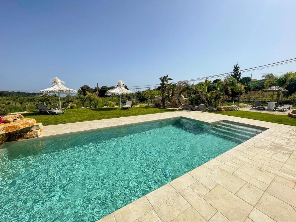 a swimming pool in the middle of a yard at Appartamenti in Villa Nature con vista mare e monti in Scopello