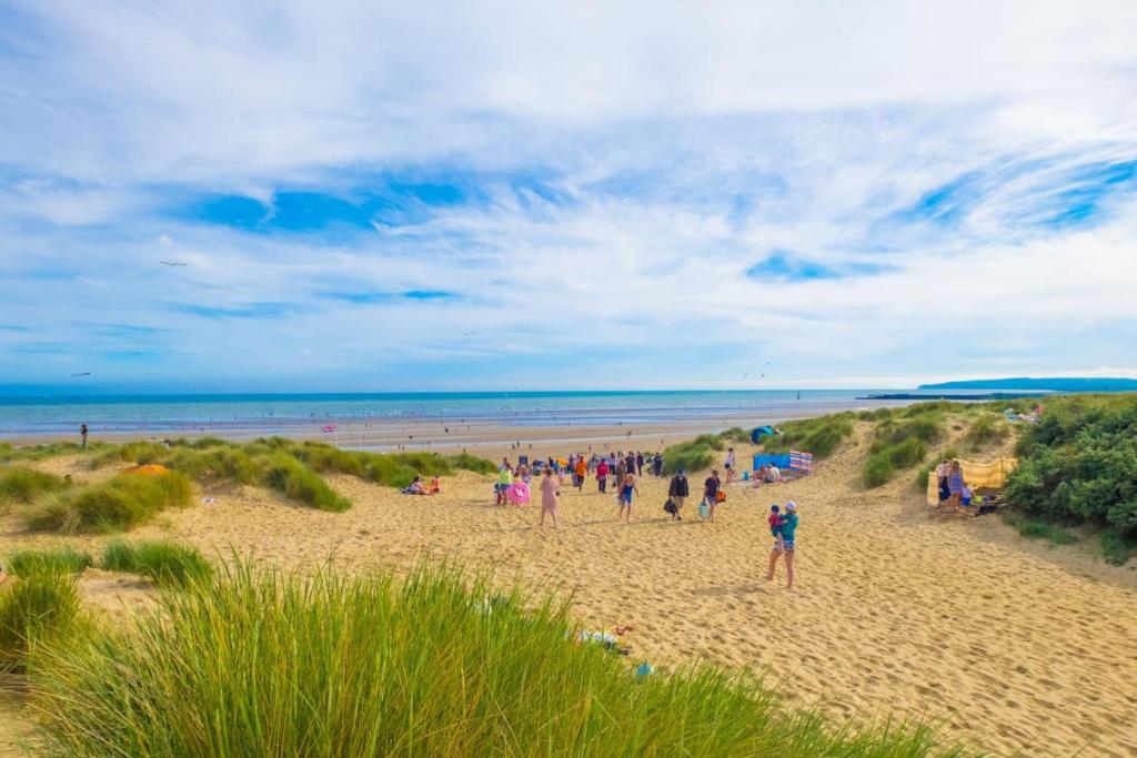 a group of people standing on a beach at MP250 Camber Sands Holiday Park in Camber