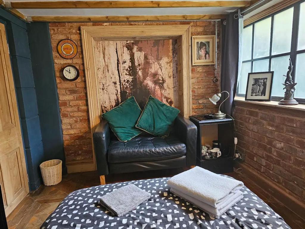 a living room with a leather chair and a couch at City Centre Stylish Hideaway in Exeter