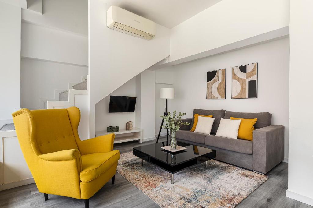 a living room with a couch and a chair at BNBHolder Calm Duplex Retiro Free Parking in Madrid