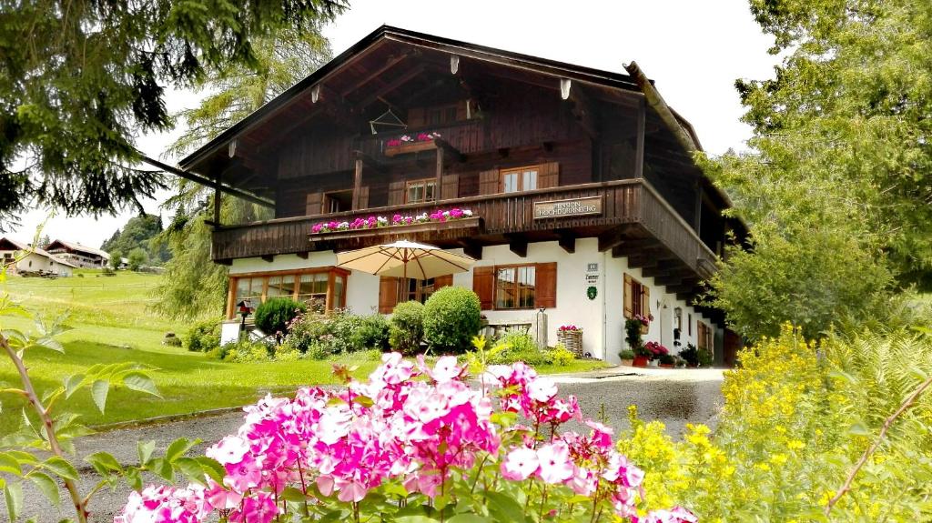 un gran edificio con flores delante en HOCHDÜRRNBERG WATZMANN Doppelzimmer mit Bad Balkon Gästeküche - Frühstück optional, en Dürrnberg