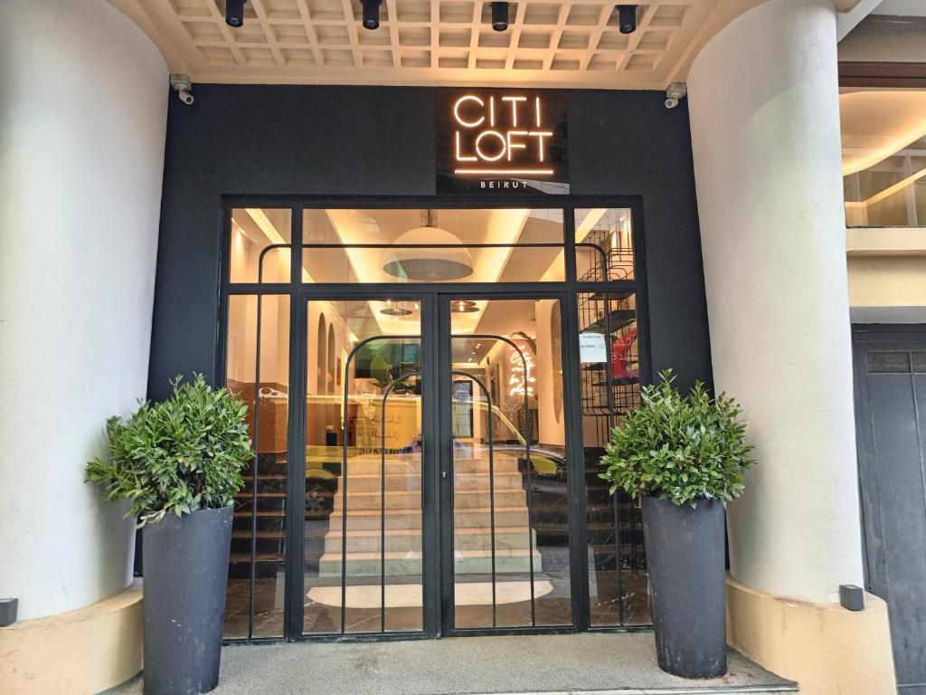 a front door of a hotel with two potted plants at Citi Loft Furnished Apartments in Beirut
