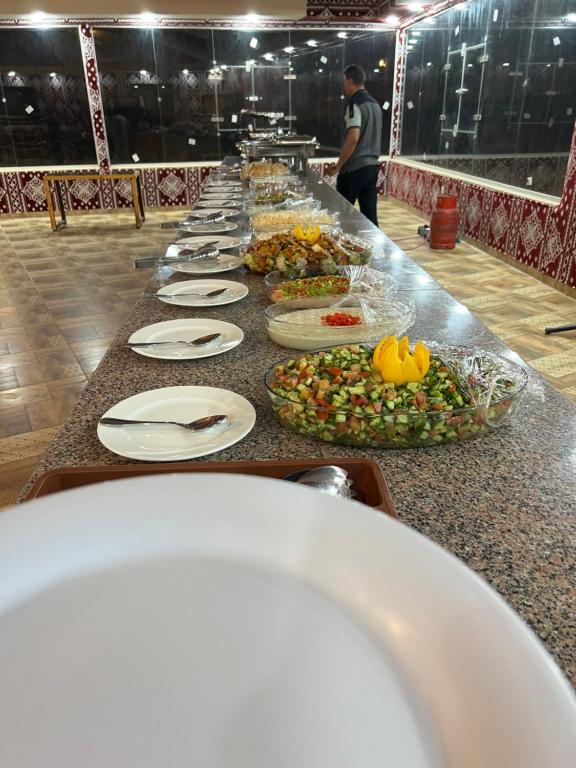 a long buffet line of plates of food on a table at Princess luxury camp in Wadi Rum